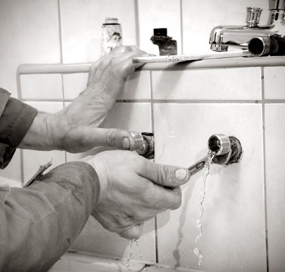 a leaking bathroom faucet is being fixed